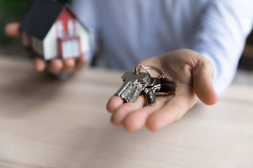 A real estate agent's hand gives the keys to a new house