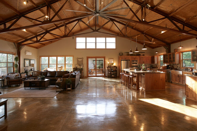 Open-concept barndominium interior with exposed trusses and clear-span layout