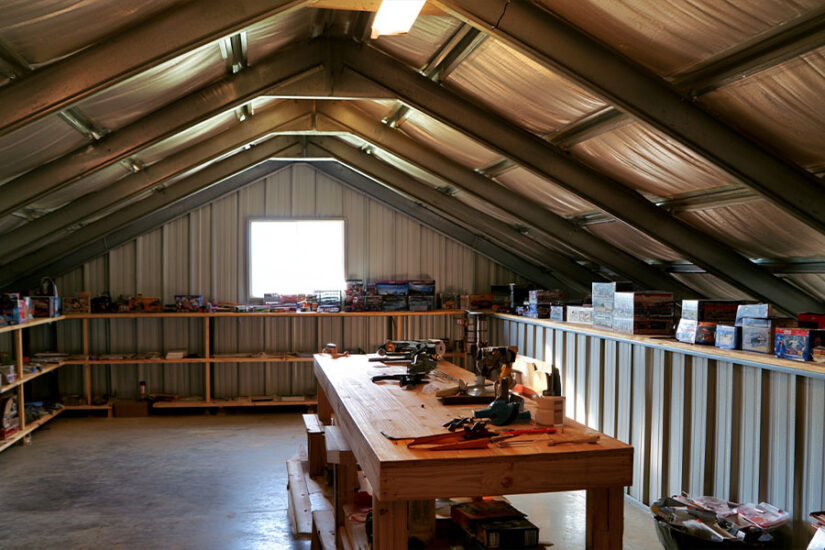 Insulated garage loft set up as a hobby room under a sloped steel roof